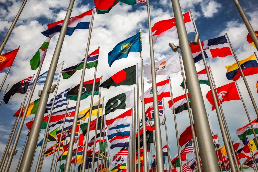Low angle shot Several international flags mounted on flag poles waving in wind in Doha Qatar