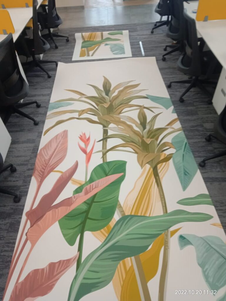 a colourful and decorative wallprint on vinyl laid out on the floor of an office before being installed
