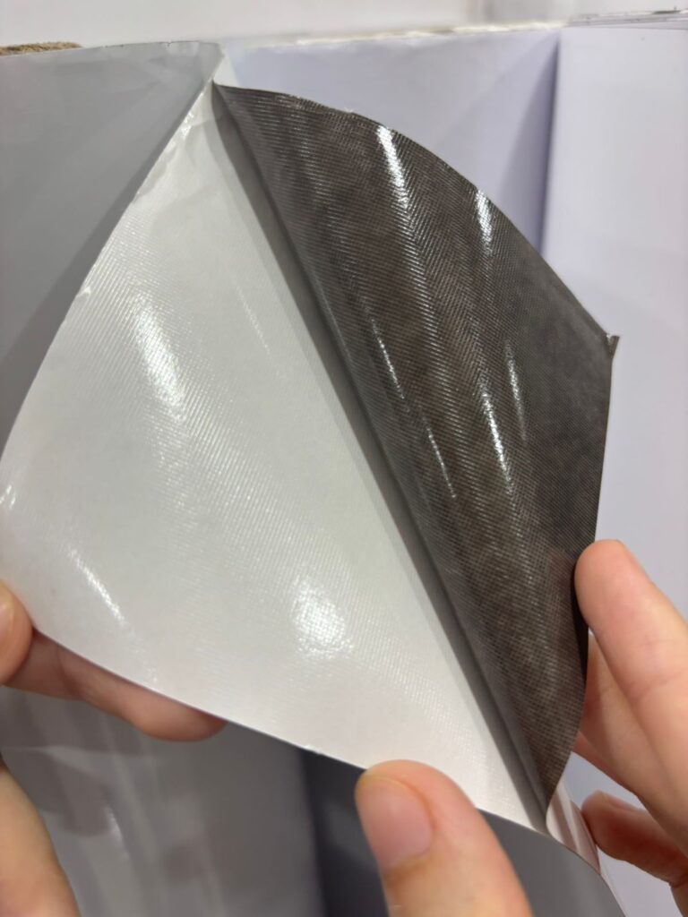Air release channels on the underside of a specialised vinyl media to ensure a ensure a bubble free pasting of the sticker without wrinkles or creases - the vinyl media is being lifted from the release liner beneath