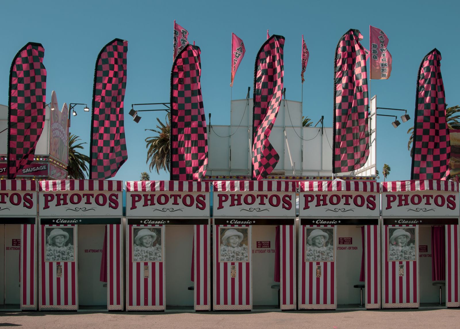 photo booth on a street topped with tear-drop flags mounted on the roof with the flag cloth waving in the breeze