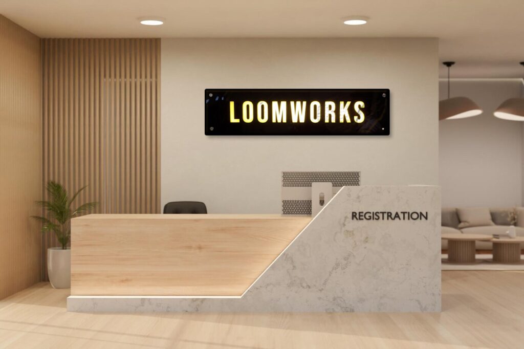 A classy looking logo board installed in the Loom Works corporate office reception area. The signboard is made out of White acrylic letters mounted on a black acrylic base plate. Each of the letters is also brightly glowing and lit up by the leds embedded within the glow sign