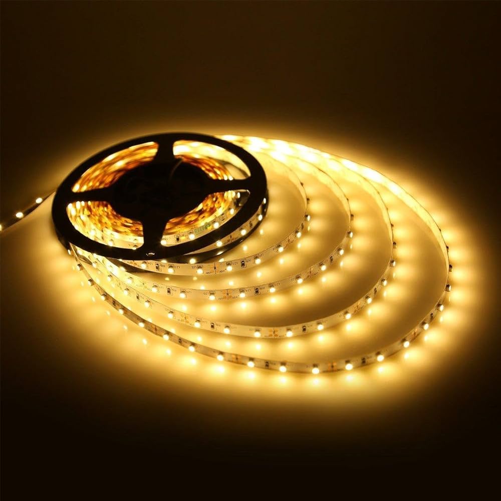 A flexible strip of brightly glowing warm white LEDs is being unspooled from a circular spindle