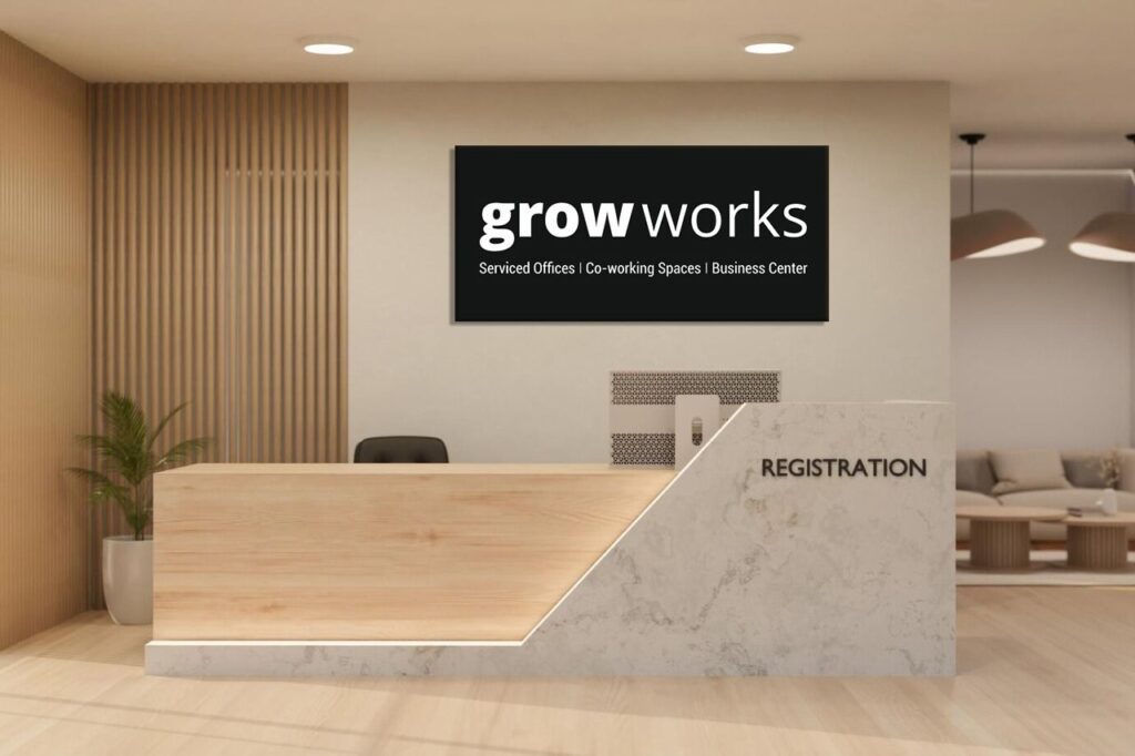 The logo sign for the Grow Works company created with laser cut white acrylic letters fixed on top of a black coloured acrylic base plate and installed in the lobby of their office