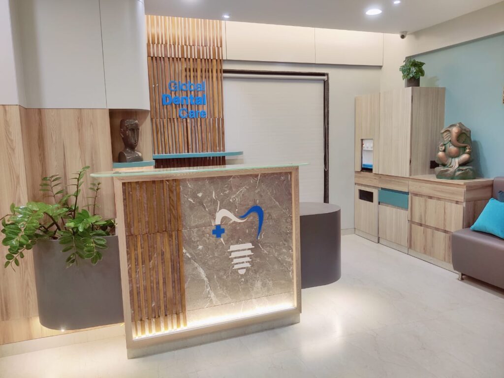 An acrylic logo laser cut in the shape of a tooth implant. This logo is pasted Reception counter of the Global Dental Clinic waiting room.
