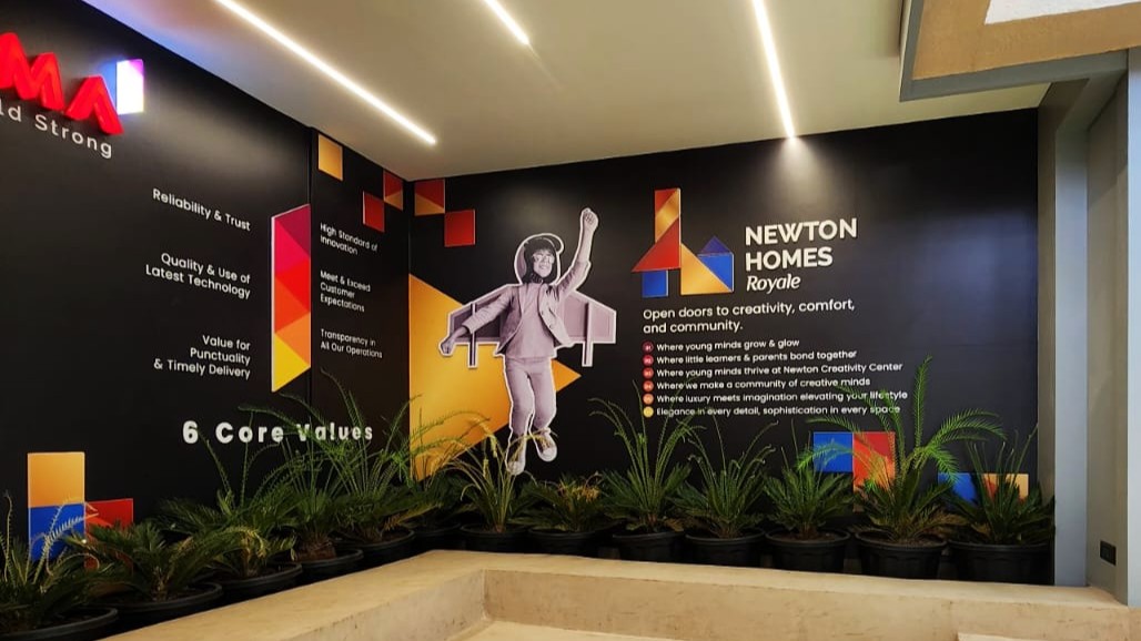 The logo and tagline of Newton Homes, along with the key features of their construction project, are all laser-cut from white and colourful acrylic sheets. These elements are then mounted on a wall inside their office to create a stunning 3D wall mural.