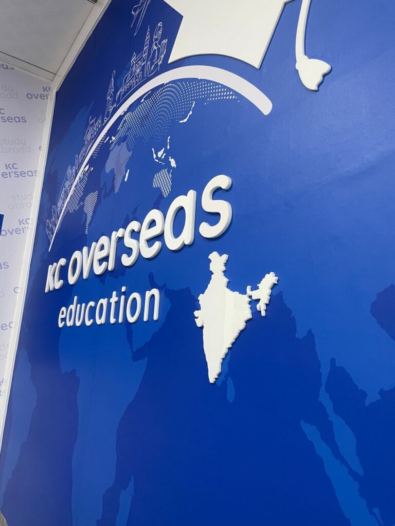 A side view showing 3D laser-cut acrylic letters of the KC Overseas Education Company fixed on a wall inside their office