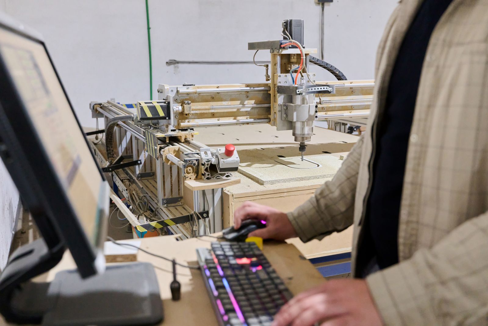 A Operator Entering Coordinates on Computer for CNC Machine to Precisely Cut Wooden Pieces