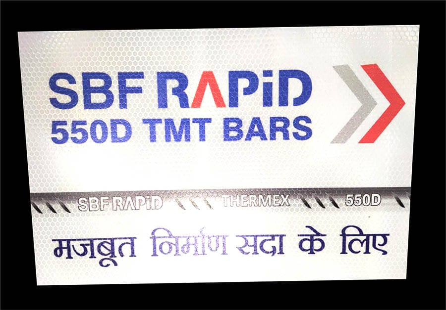 A company's logo and product name printed on prismatic reflective vinyl mounted on a plastic sheet