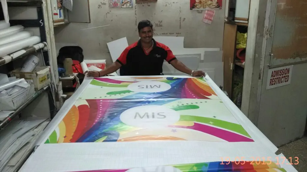 person laying out a large piece of cloth on which the custom design of a company’s flag has been printed