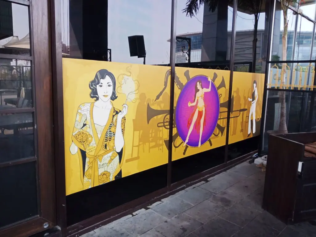 a high resolution Vinyl print with classy looking artwork pasted on a glass partition at the entrance of a cafe