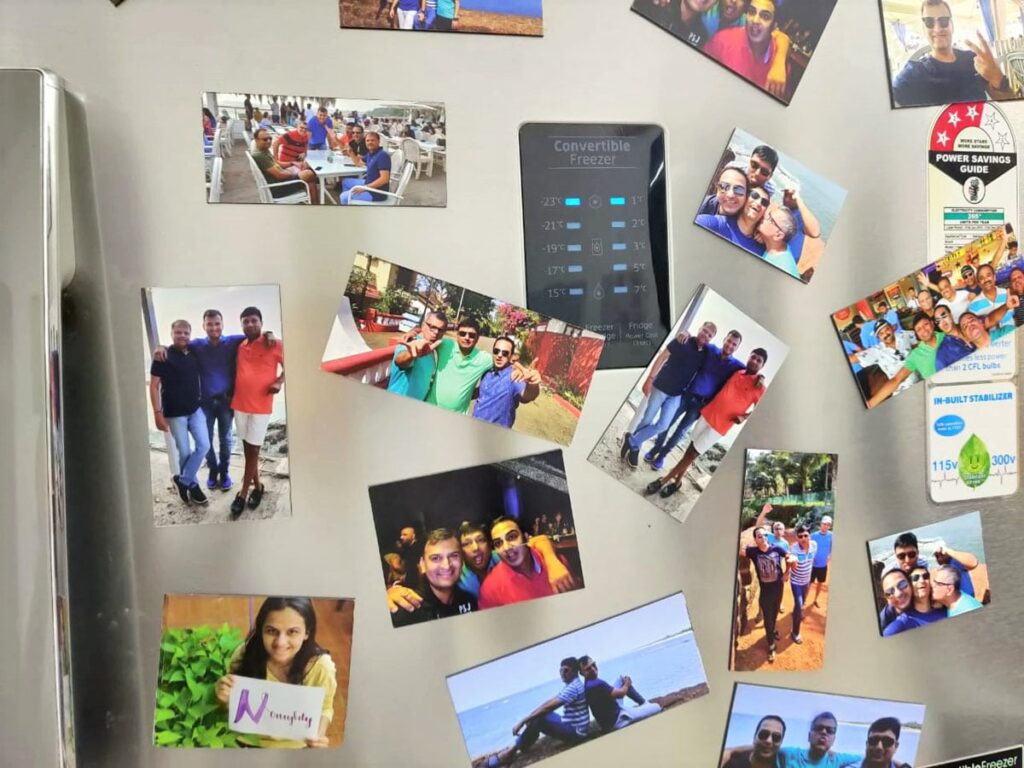 fridge magnets placed on the door of a fridge showing photos of friends and family