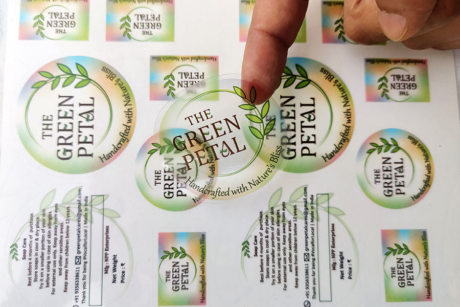 A see-through transparent kiss cut sticker cut in the shape of a circle with a sheet of similar labels in the background