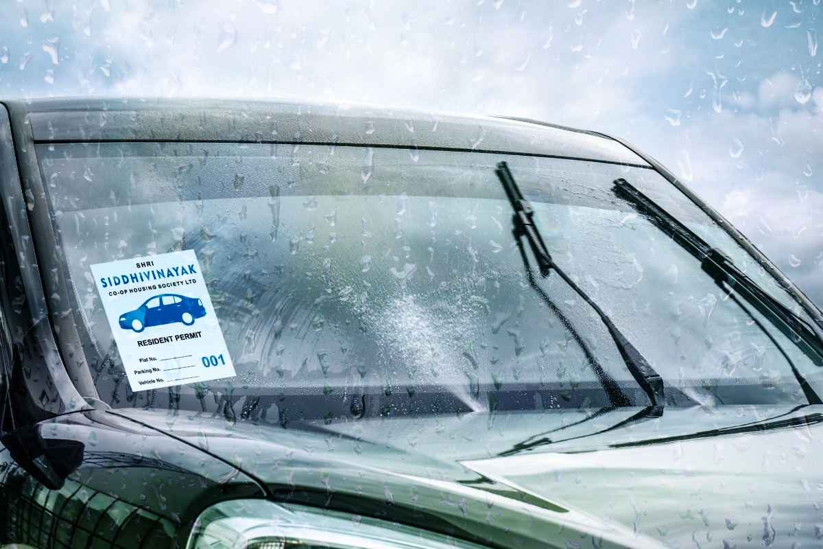 a weatherproof parking sticker pasted on a car's windshield that is outdoor grade and resistant to rain, sunlight, dust, and scratches.