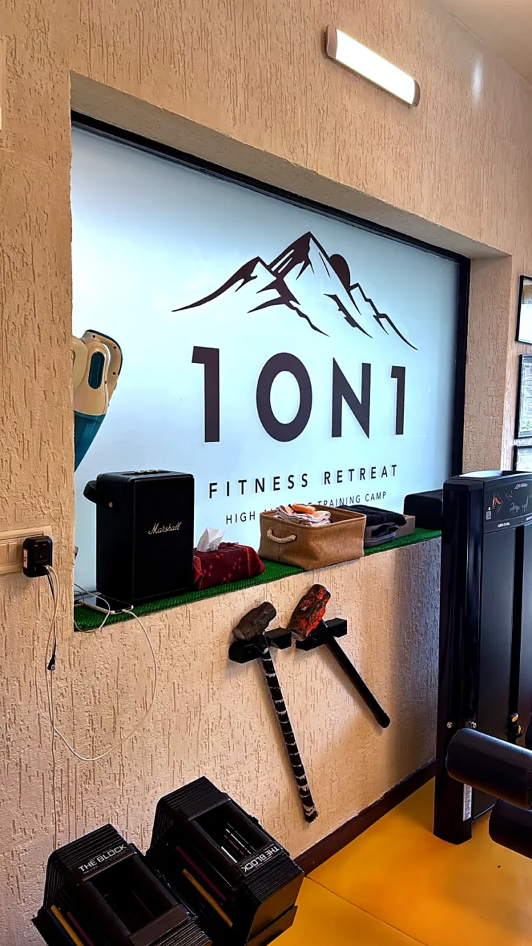 1ON1 Fitness Retreat logo printed on frosted film on a gym window, daylight coming through