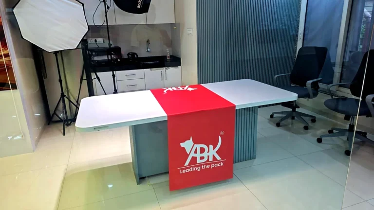 Red ABK Exports table runner with the logo laid across a white table