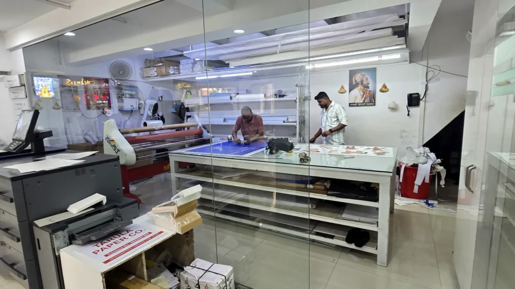 Finishing and lamination room seen through glass, with the XL Jet laminator