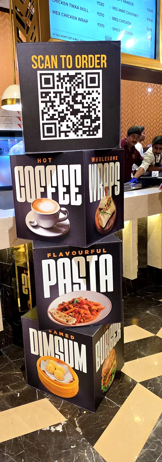 Stacked sunboard cubes printed with coffee, pasta and dim sum, topped with a Scan to Order QR code