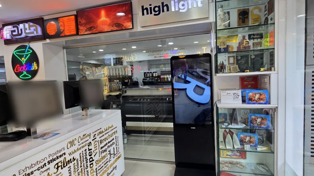 Front counter at Orchid Digitals looking into the machine room, with a glass cabinet of small printed products