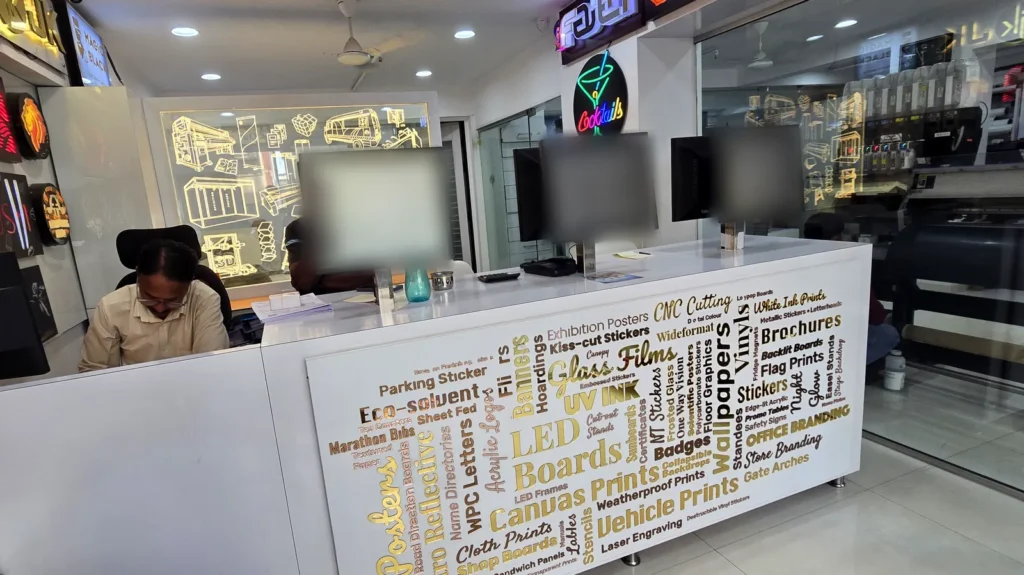 Front desk at Orchid Digitals with laser-cut gold and rose-gold acrylic letters naming our products and services