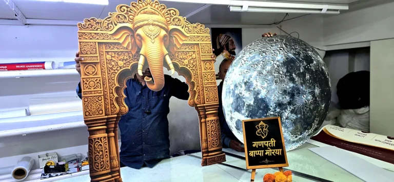 Shape-cut temple arch with an elephant-head crown beside a printed full moon, made for Ganesh Chaturthi