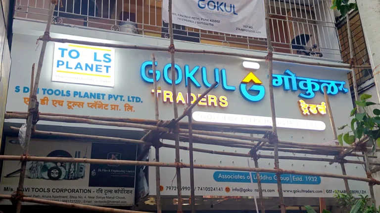 Gokul Traders and Tools Planet 3D LED acrylic fascia lit at dusk, English and Marathi