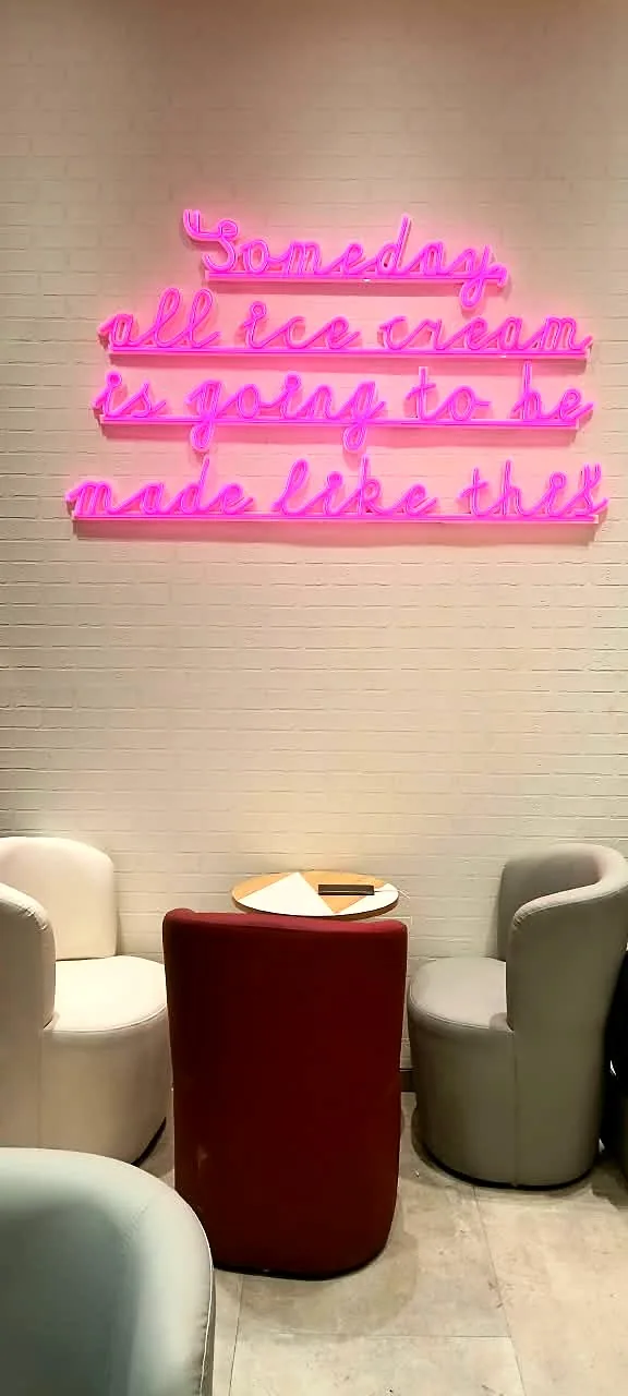 Pink LED neon quote on the café wall: Someday all ice cream is going to be made like this