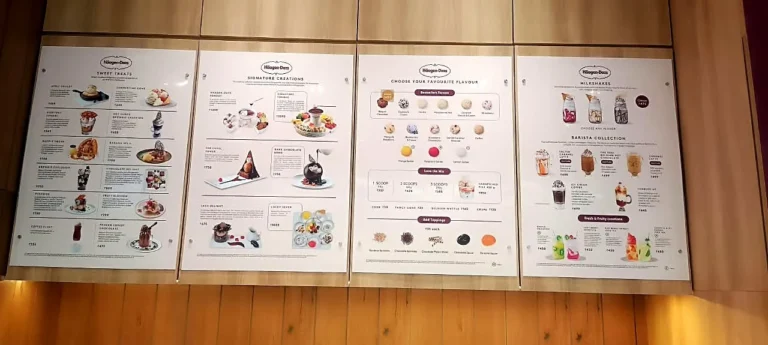 Four menu boards on the wooden wall behind the counter