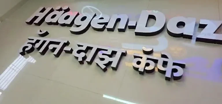 The English and Marathi letters laid out in our Pune workshop: white acrylic faces, sides painted in the brand’s maroon