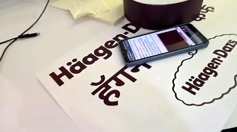 Checking the painted letter sides against the brand colour, next to the full-size layout