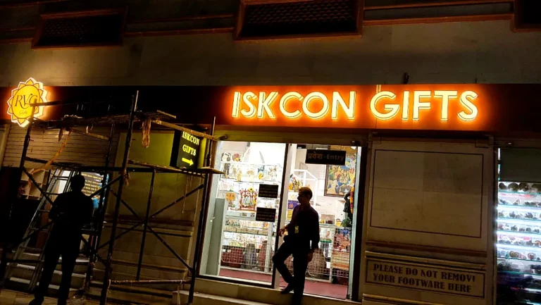 ISKCON Gifts fascia sign glowing at night above the temple gift shop