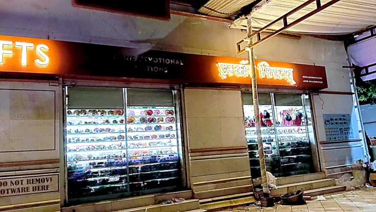 Devanagari end of the ISKCON Gifts fascia lit at night