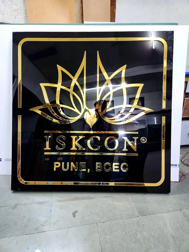Mirror-gold acrylic logo on black acrylic in daylight