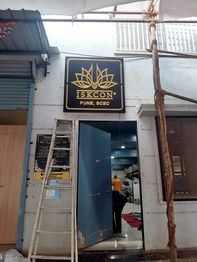 The ISKCON Pune BCEC logo board above the centre’s doorway, seen from the lane