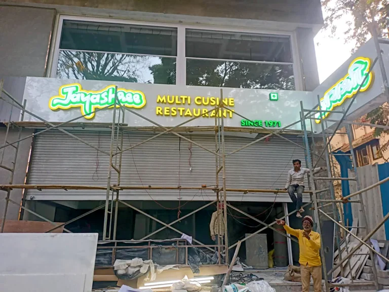 The L-shaped ACP fascia of Jayashree, Viman Nagar, with the English logo on the front and the Marathi name on the return panel, lit during installation