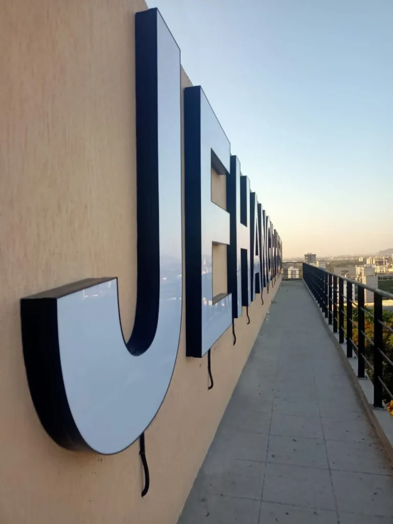 The giant J of JEHANGIR from the terrace walkway: white acrylic face, black aluminium sides
