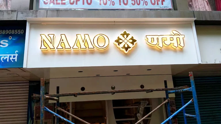 Namo Jewels shop sign in white acrylic letters with a gold edge, English and Marathi