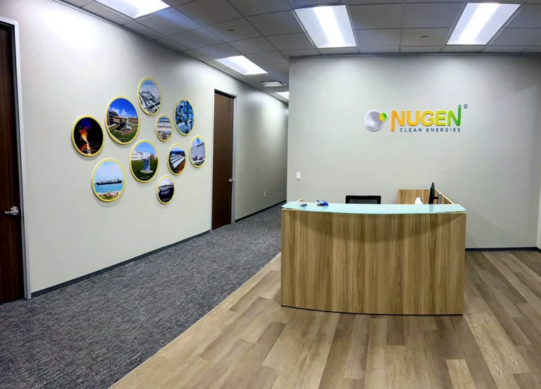 Nugen Clean Energies office in Houston: the acrylic NUGEN Clean Energies logo on the wall behind the reception desk and the round photo wall along the corridor