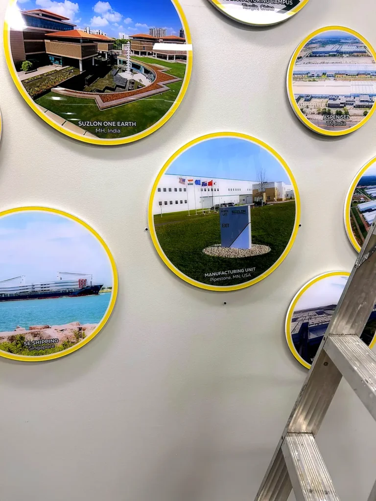 Round acrylic photo prints being fitted, with a ladder in the frame