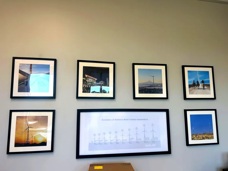 Framed photo prints and a wide wind turbine generations print in a conference room