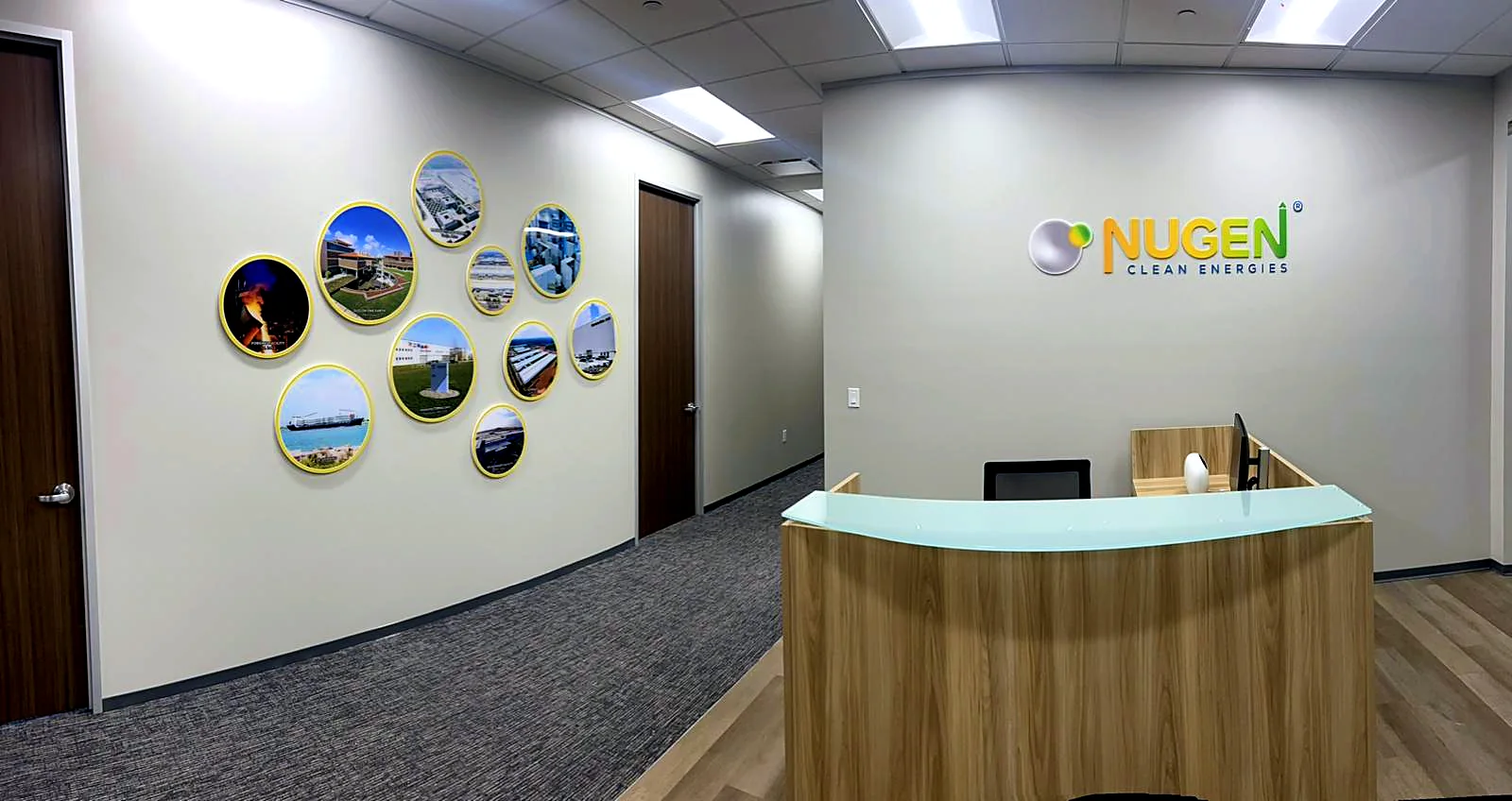 Nugen Clean Energies office in Houston: the reception with the acrylic logo and the round photo wall along the corridor