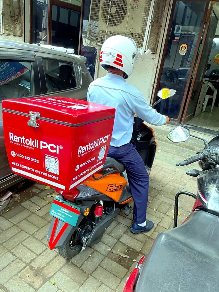 Rentokil PCI branded scooter with white-ink graphics and a branded delivery box