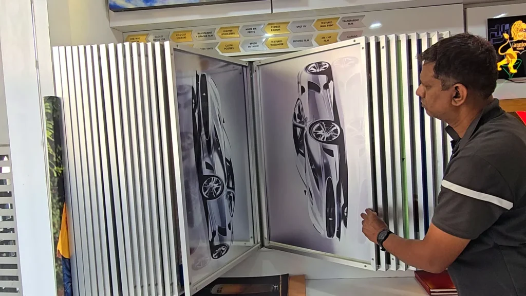 Sample panels showing a car printed on film, held up by Sachin