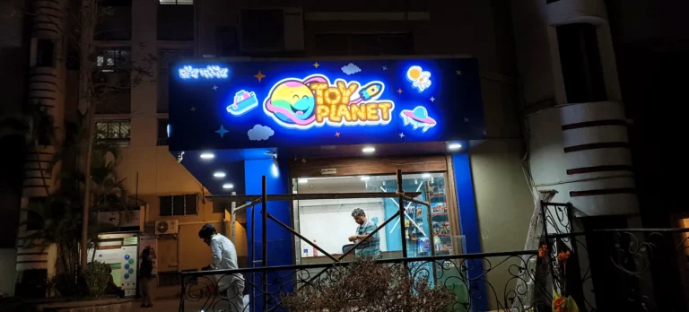 The smaller Toy Planet face lit up at night, seen from the street