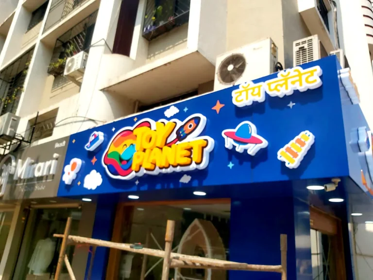 The corner of the Toy Planet fascia by day, with the Marathi name on the side face