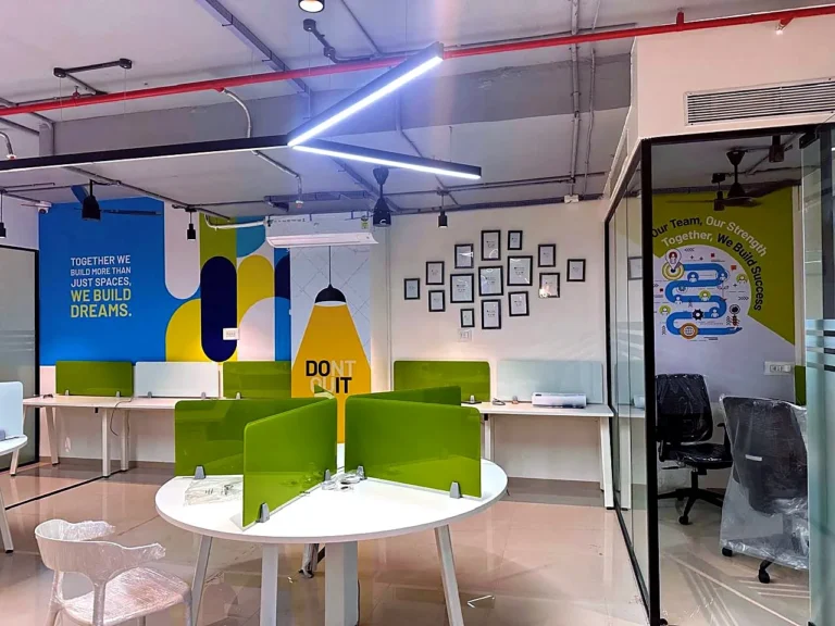 Twice office in Pimpri-Chinchwad: a blue and yellow wall print, a DON’T QUIT pillar and a printed HR cabin wall around green workstations